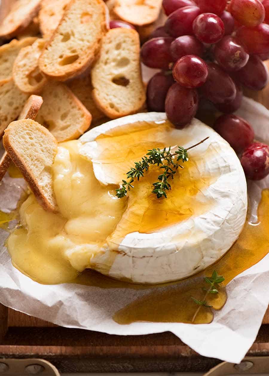 Baked Brie served with crisp breads and grapes