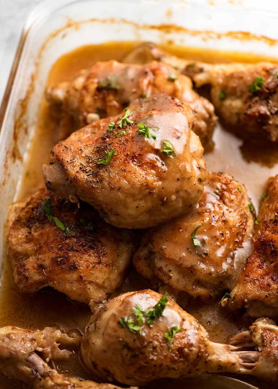 Close up of crispy baked chicken thighs and drumsticks with gravy