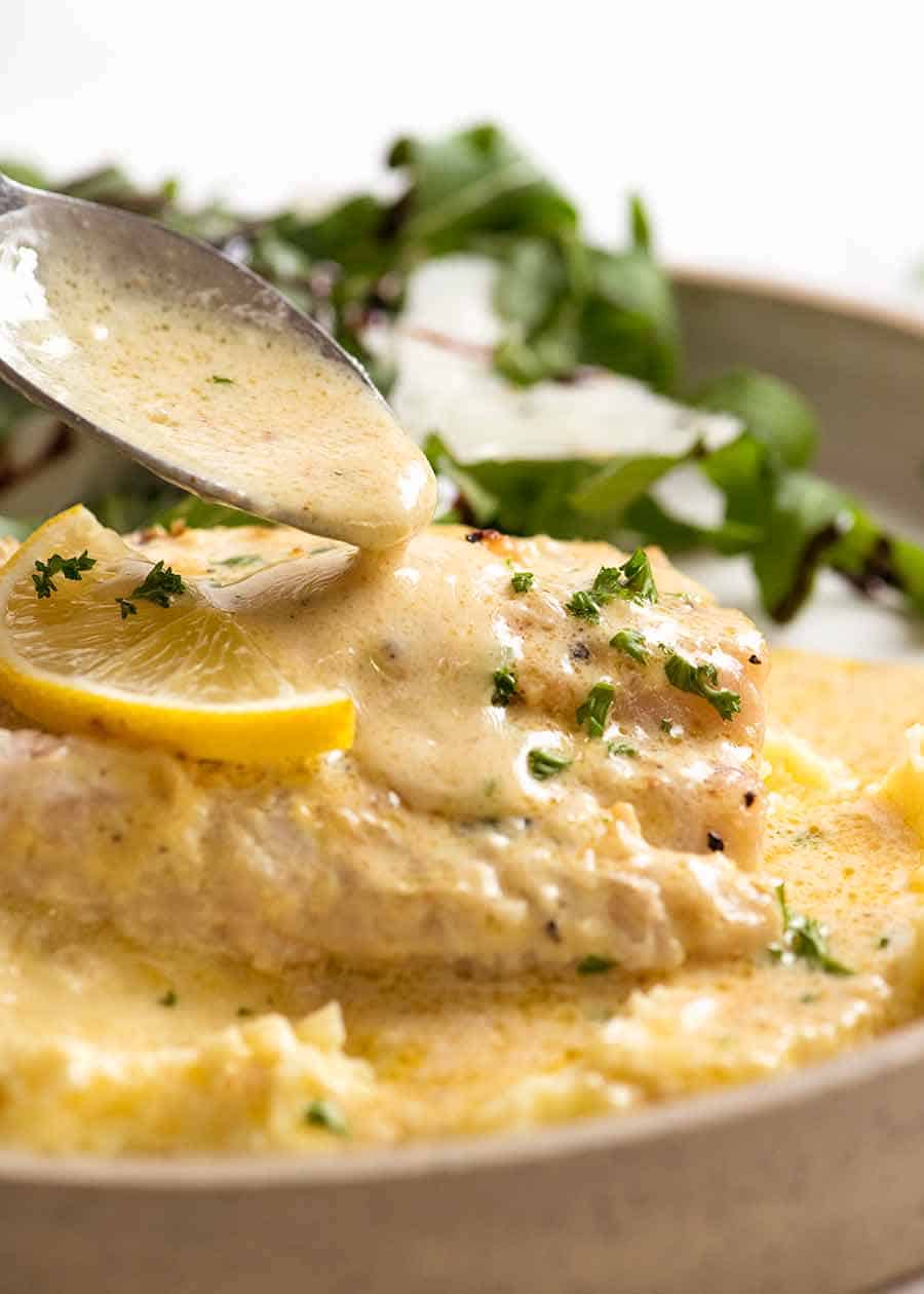 Spoon drizzling Lemon Cream Sauce over Baked Fish (one pan fish and sauce recipe!)