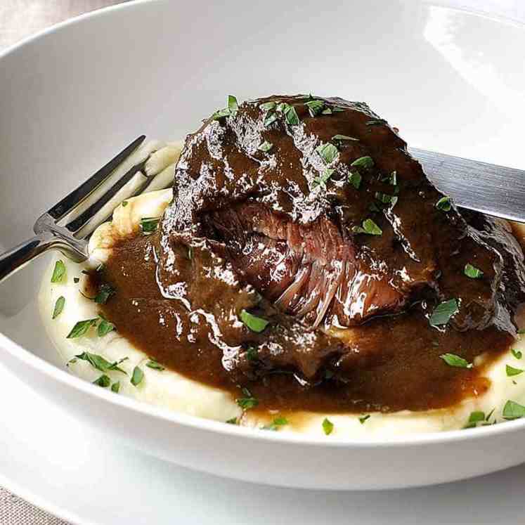 Slow cooked beef cheeks in red wine sauce on creamy mashed potato