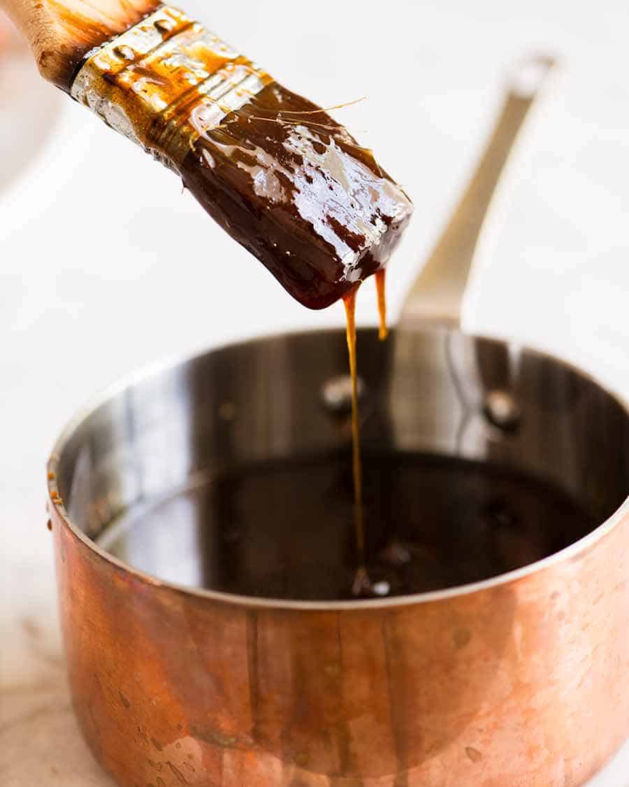 Basting brush dipping in Brown Sugar Ham Glaze