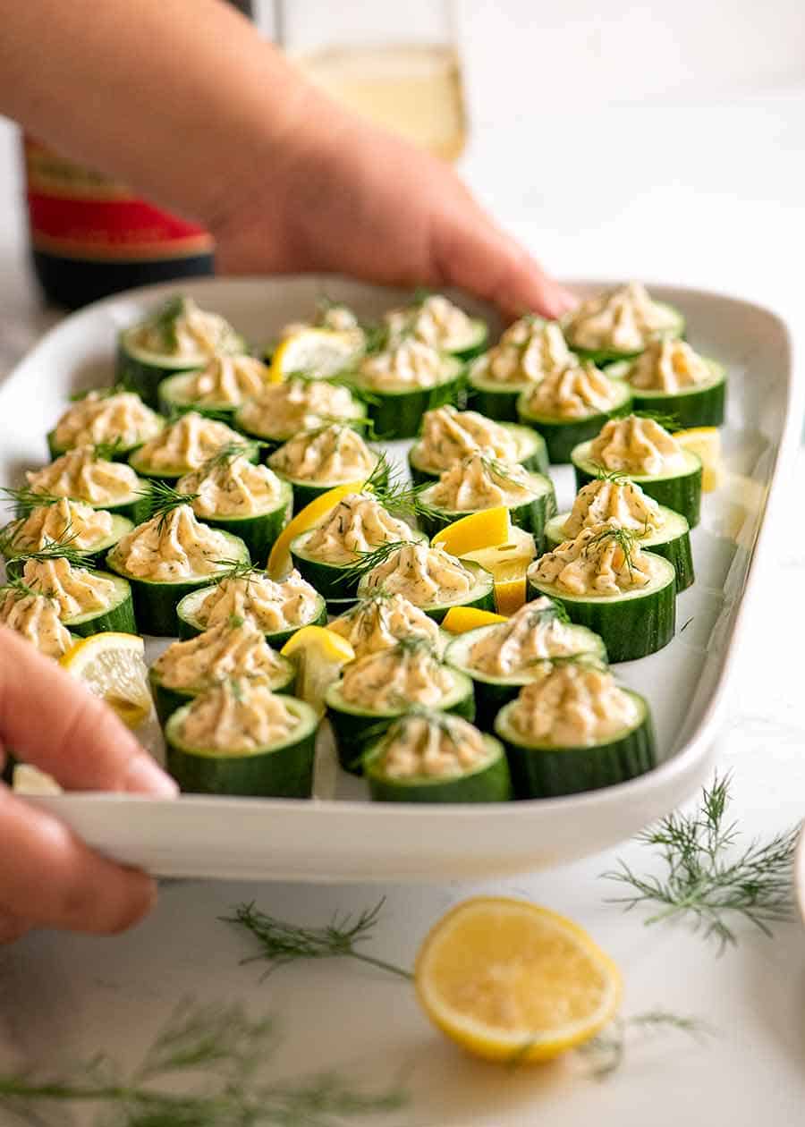 Platter of cucumber appetisers topped with smoked salmon mousse