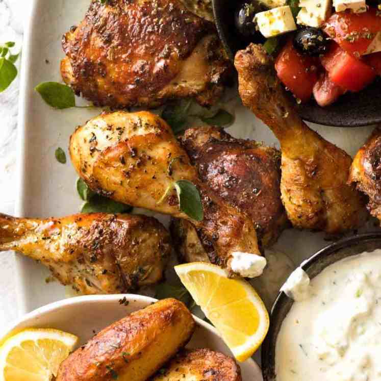 Greek Chicken on a plate with Greek Salad, Lemon Roasted Potatoes and Tzatziki on the side