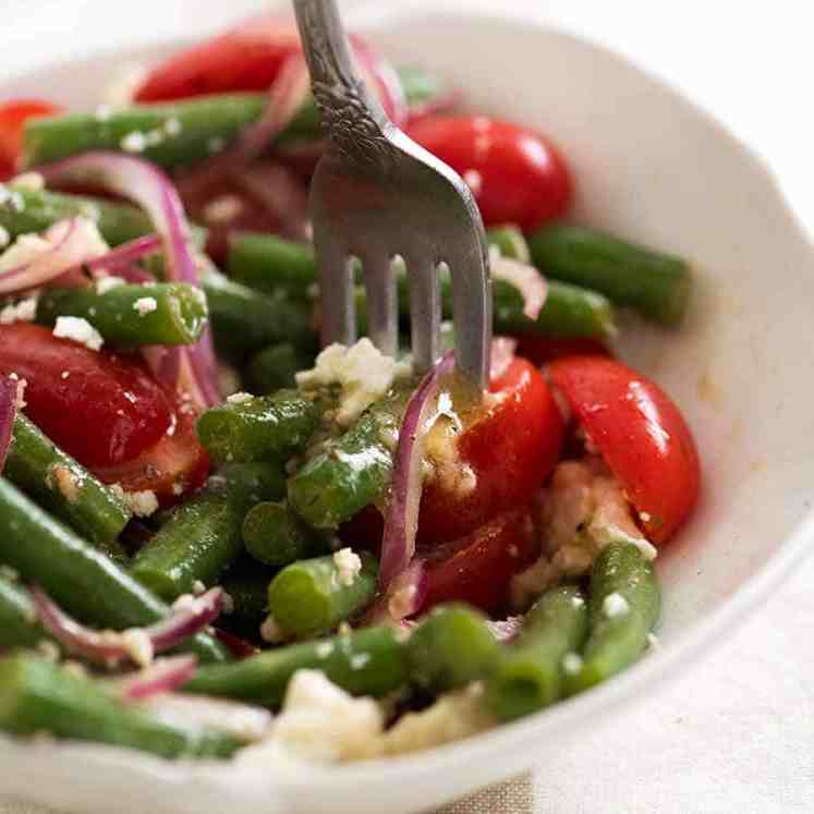 Close up of forkful of Green Bean Salad with Cherry Tomatoes and Feta