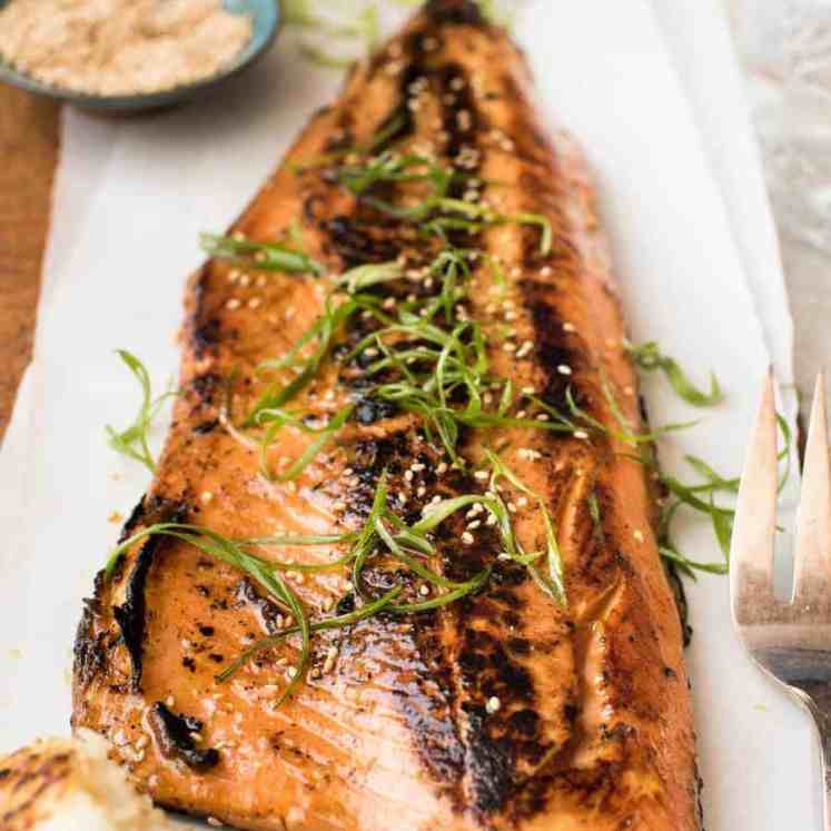 Japanese Miso Salmon Side on a wooden board garnished with steps of shallots / scallions, ready to be served.