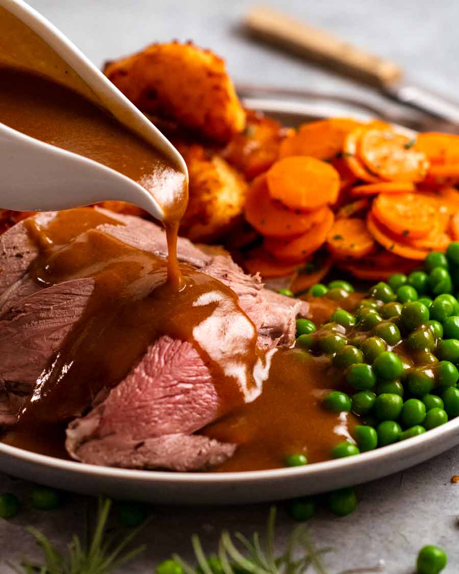 Pouring gravy over Roast lamb leg