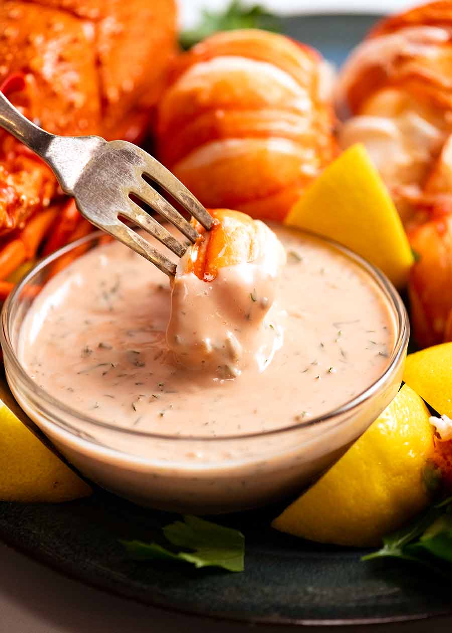 Dipping lobster into seafood sauce