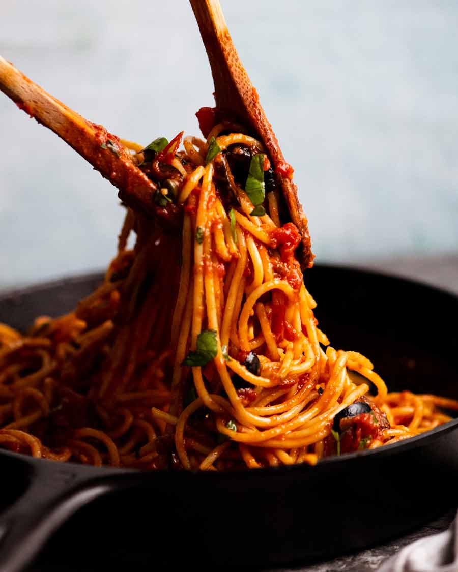 Tongs tossing Spaghetti alla Puttanesca