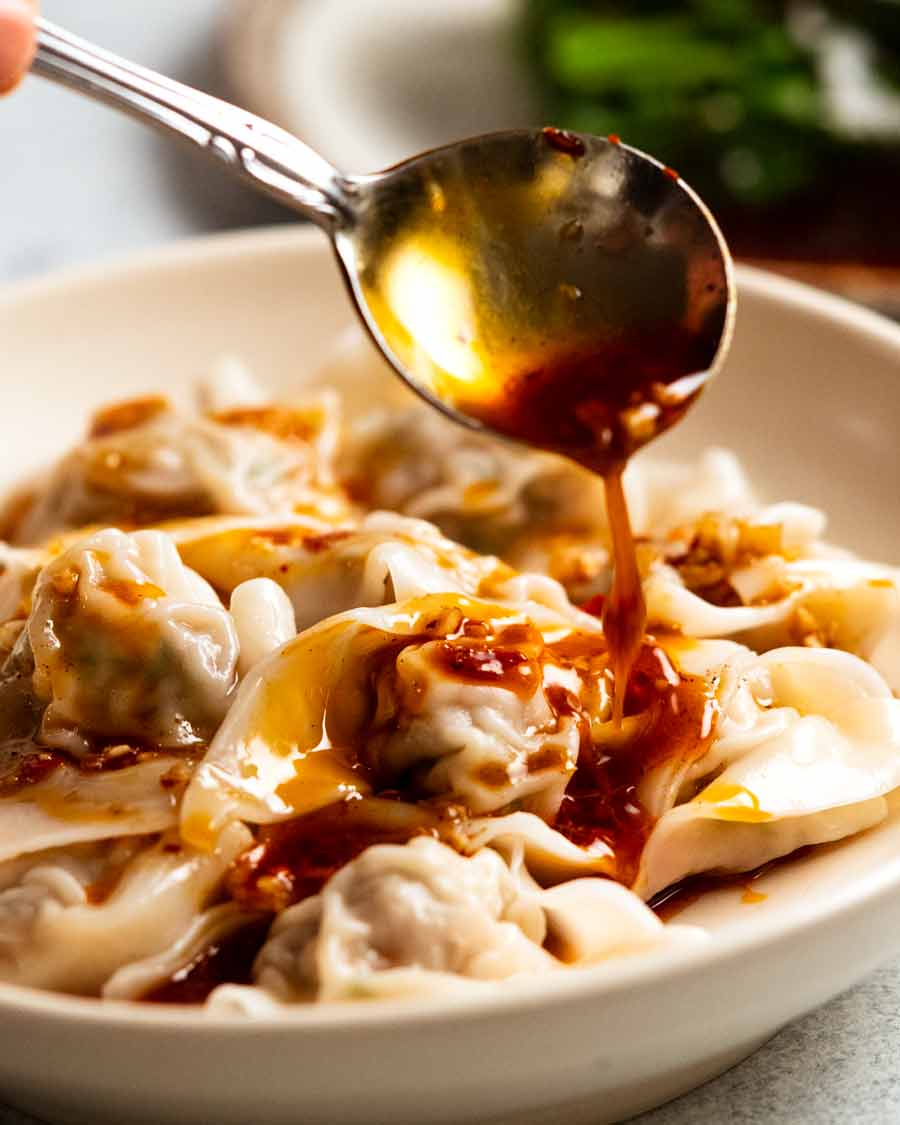 Drizzling sauce over Spicy Wontons in Chilli Sauce - Din Tai Fung