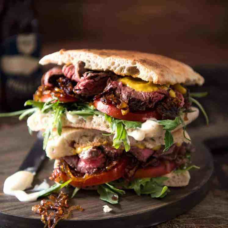 A juicy Steak Sandwich loaded with tender slices of steak, caramelised onion, garlic aioli, lettuce, tomato and mustard. recipetineats.com